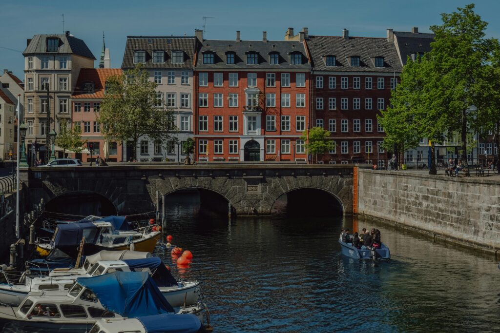 Explore the vibrant canal with colorful buildings in Copenhagen on a sunny day.